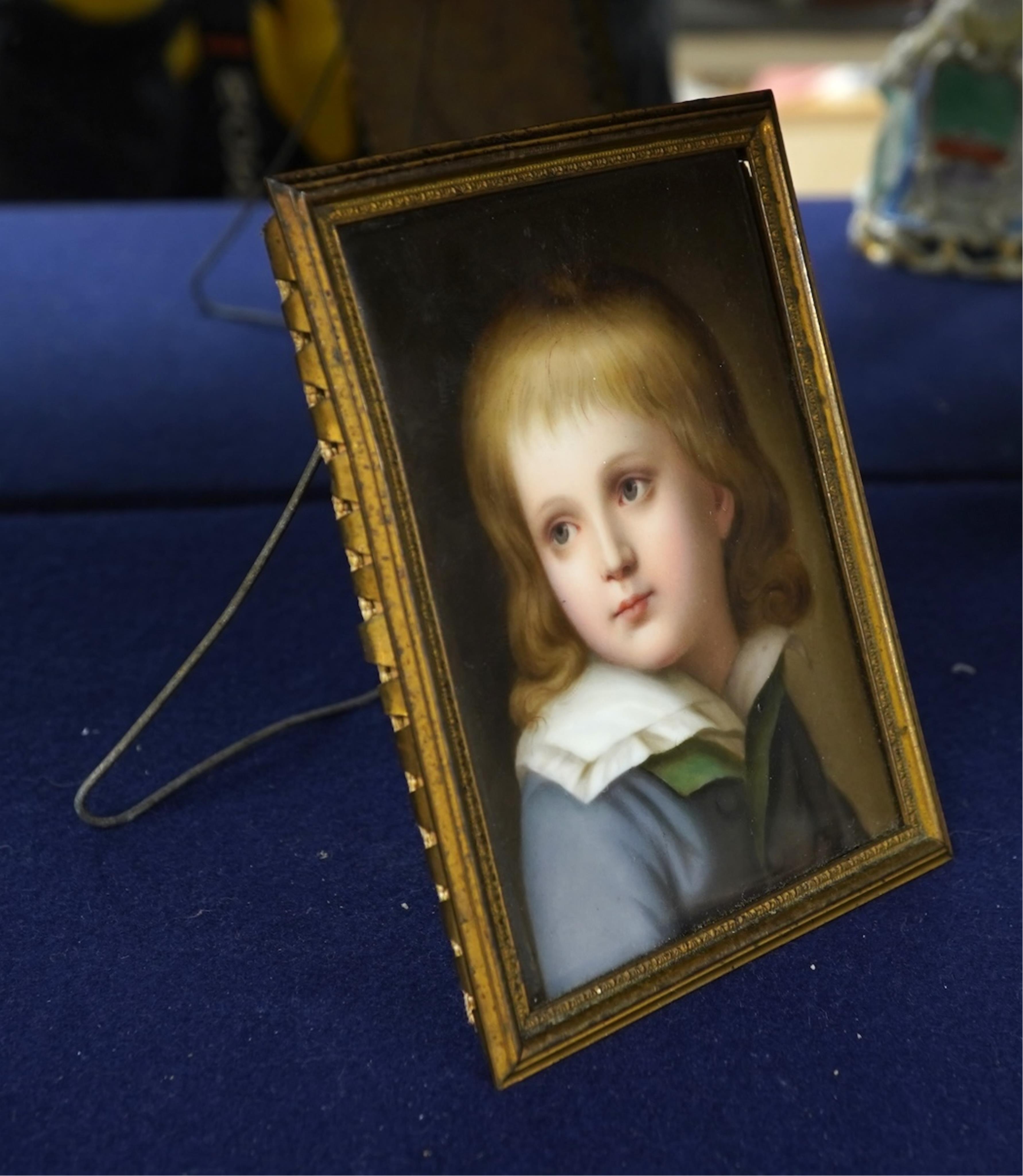 A late 19th century German porcelain plaque, painted with the portrait of a boy, possibly Dauphin Louis XVII, in gilt metal frame, 11cm x 8cm